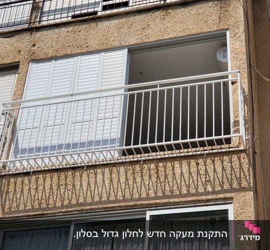 סורג ישר ממתכת בצבע לבן המותקן בחזית חלון דירה